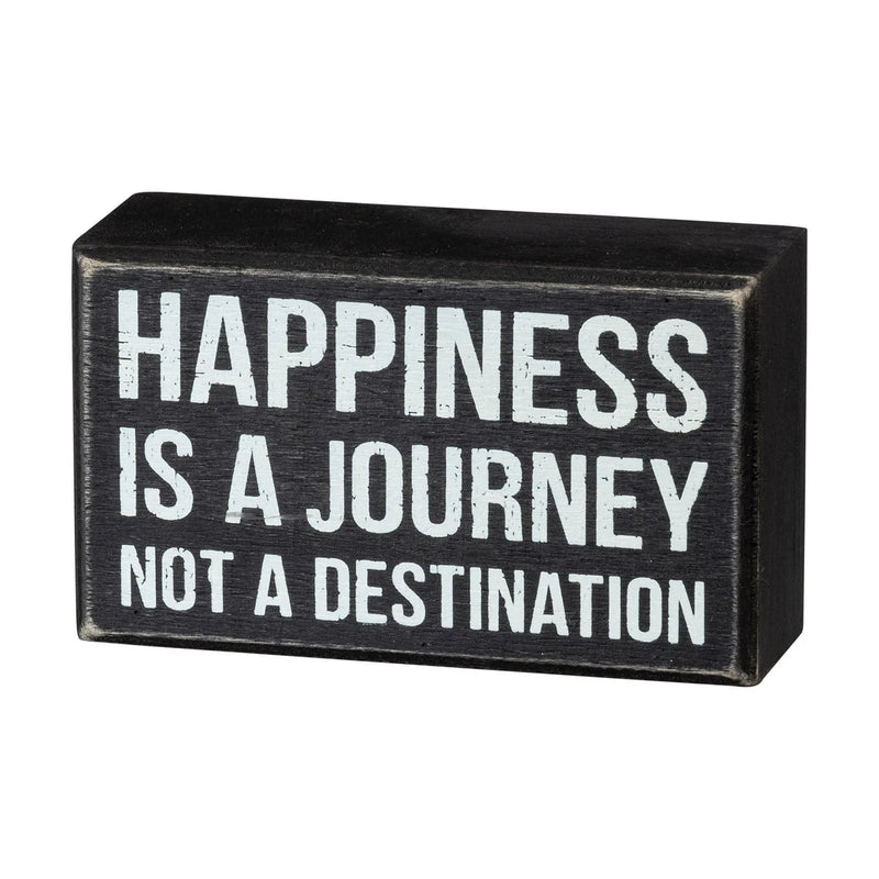 Black and white journey box sign featuring the phrase happiness is a journey not destination