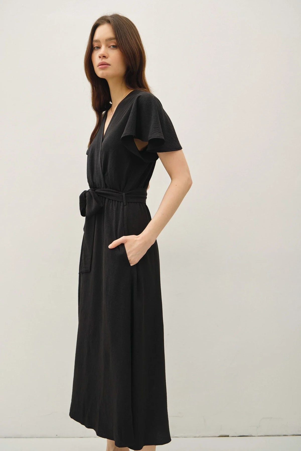 Black wrap dress with ruffle cap sleeves and V neck with tie waist, midi length