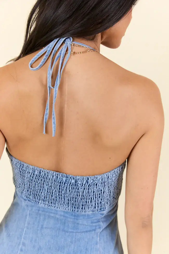 Blue denim halter dress featuring ruffle details and side zipper design