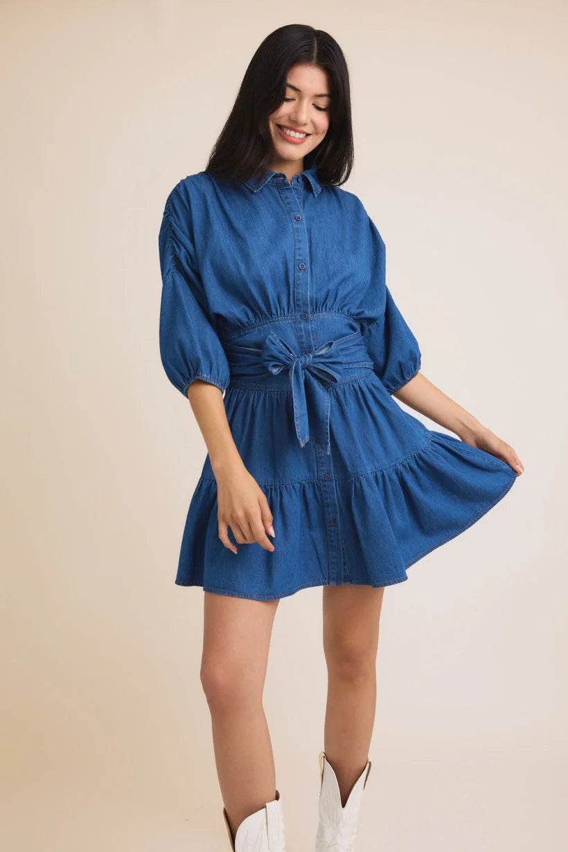 Blue denim mini dress with puff sleeves and tied waist belt from Shop Daisy, women’s boho chic clothing