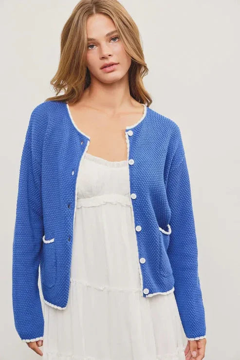 Blue knit cardigan with white trim from Shop Daisy, perfect for women’s boho chic clothing