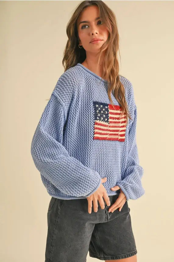 Blue knit sweater featuring an American flag, perfect for women’s boho chic clothing at Shop Daisy