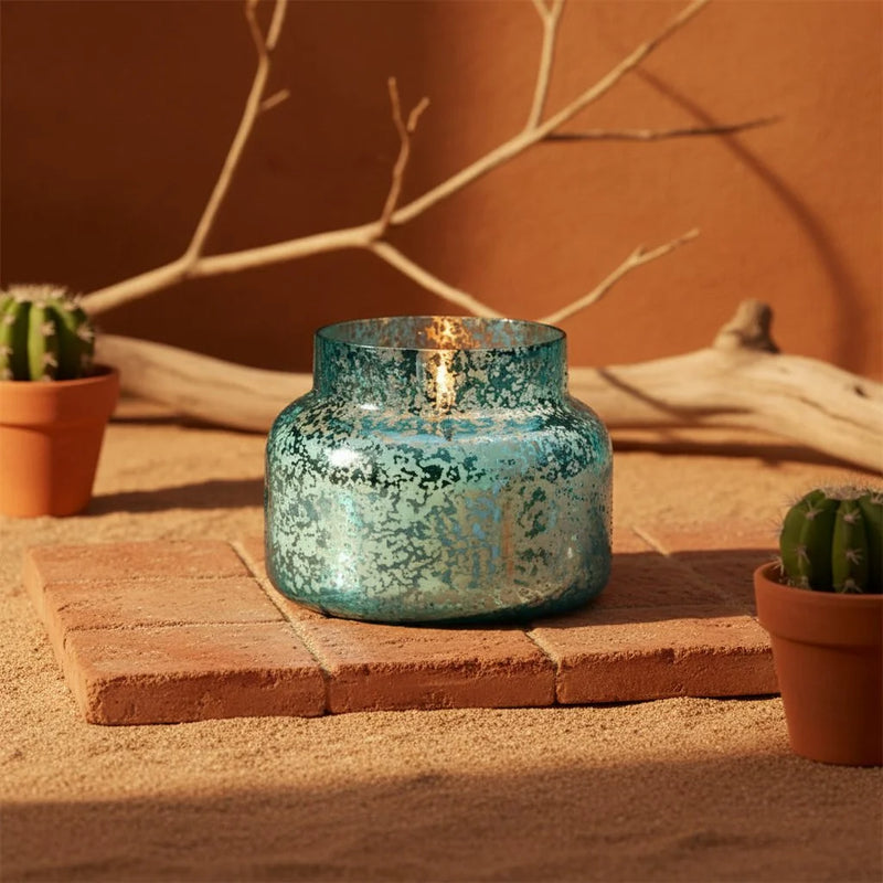 Blue mercury glass candle jar with crackled texture and flame from Capri Blue Volcano Mercury Signature Candle