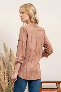 Blush-colored pleated blouse with long sleeves modeled as a multi striped button top