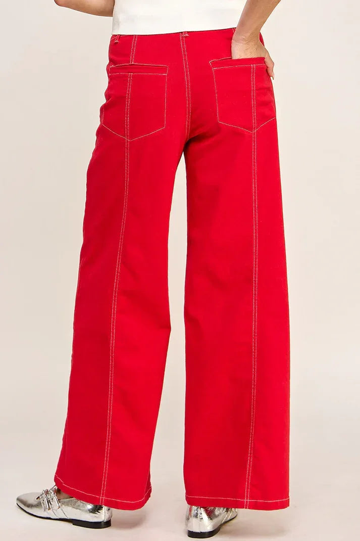 Bright red high rise wide leg denim jeans with white contrast stitching and pockets