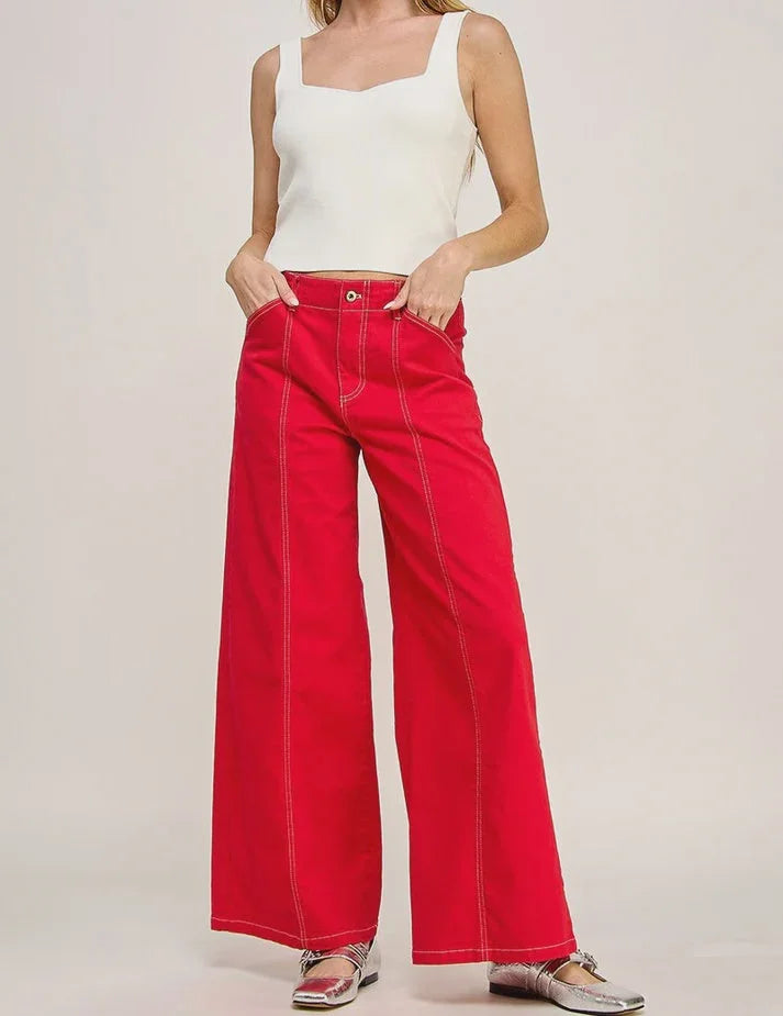 Bright red wide leg denim jeans paired with a white sleeveless top from Daisy Lane’s High Rise