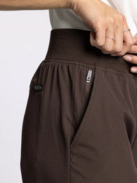 Brown supply walker pants with ribbed waistband, side pockets, and zip closures
