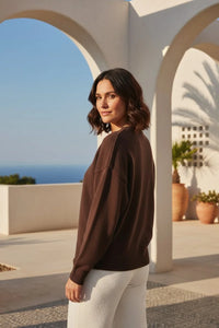 Crew neck Christmas dog sweater in brown cashmere with white pants