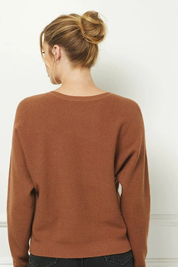 Brown knit sweater with mini waffle texture, worn by a person with blonde hair in a bun