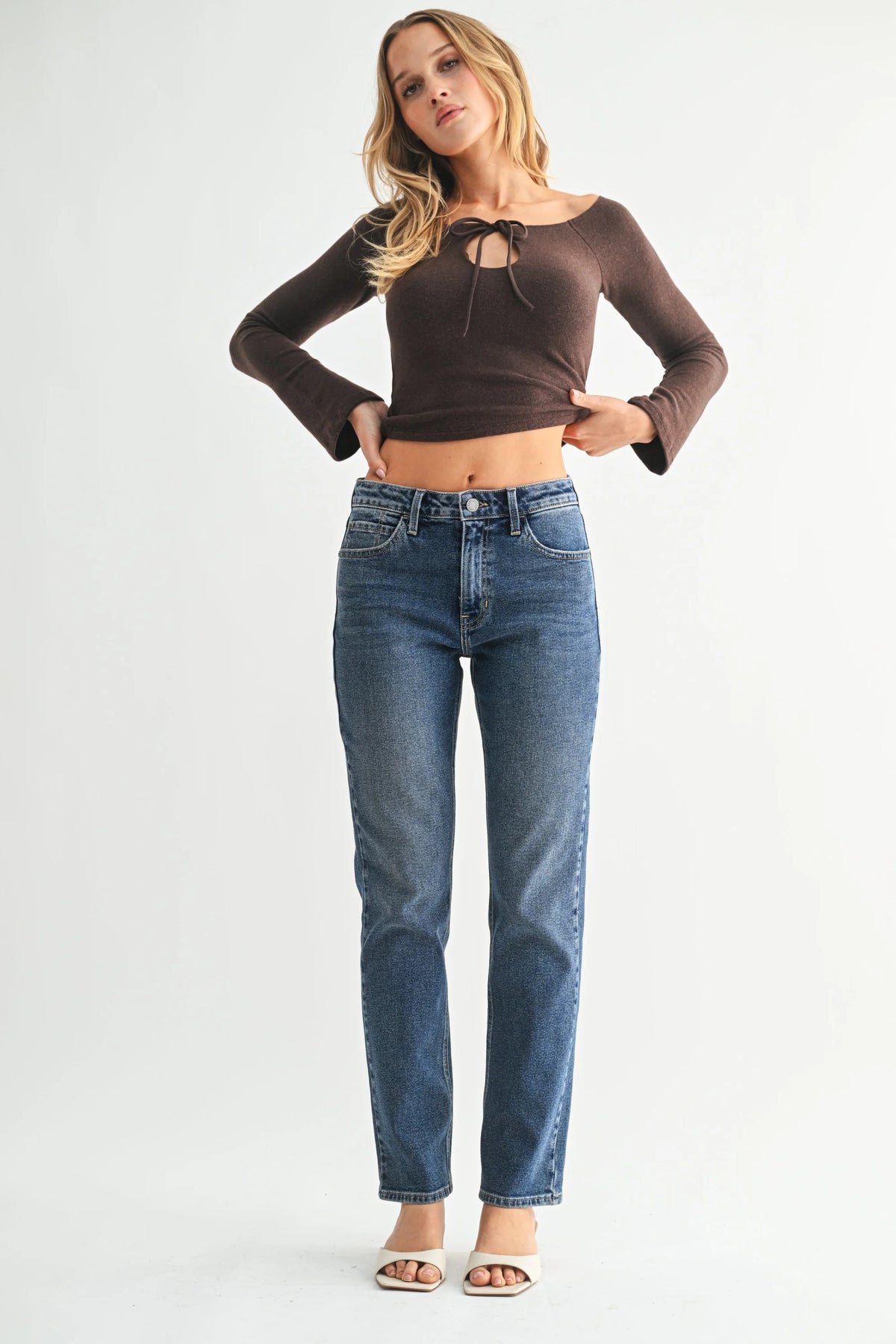Brown long-sleeve crop top with lace-up neckline over high rise straight pencil jeans
