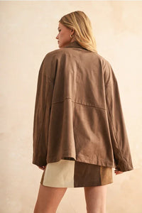 Brown oversized jacket with patch pocket design and beige shorts.