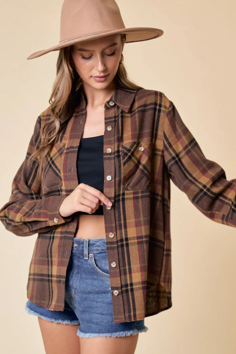 Brown plaid flannel oversized shirt styled with denim shorts and a wide-brim hat for womens boho clothes