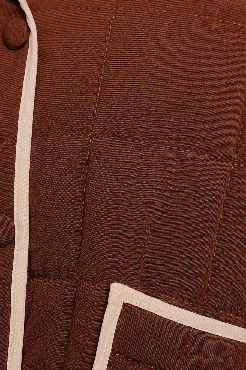 Brown quilted fabric with white trim on a Drop Shoulder High Collared Quilt Jacket