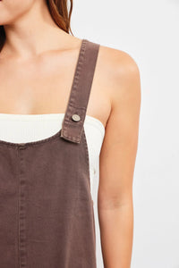 Brown overall strap attached to a denim mini dress for stylish and casual wear