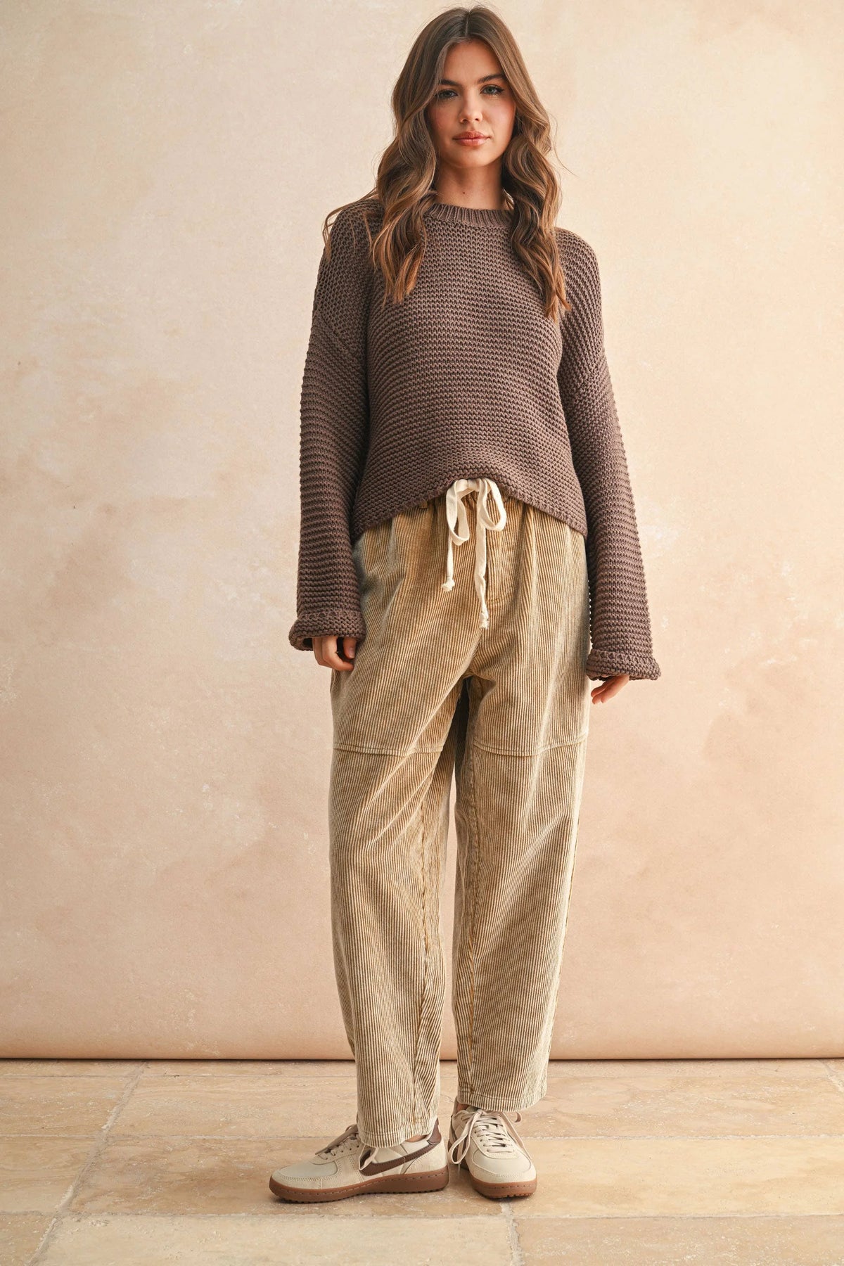 Round neck knitted sweater with brown texture, drawstring pants, white sneakers