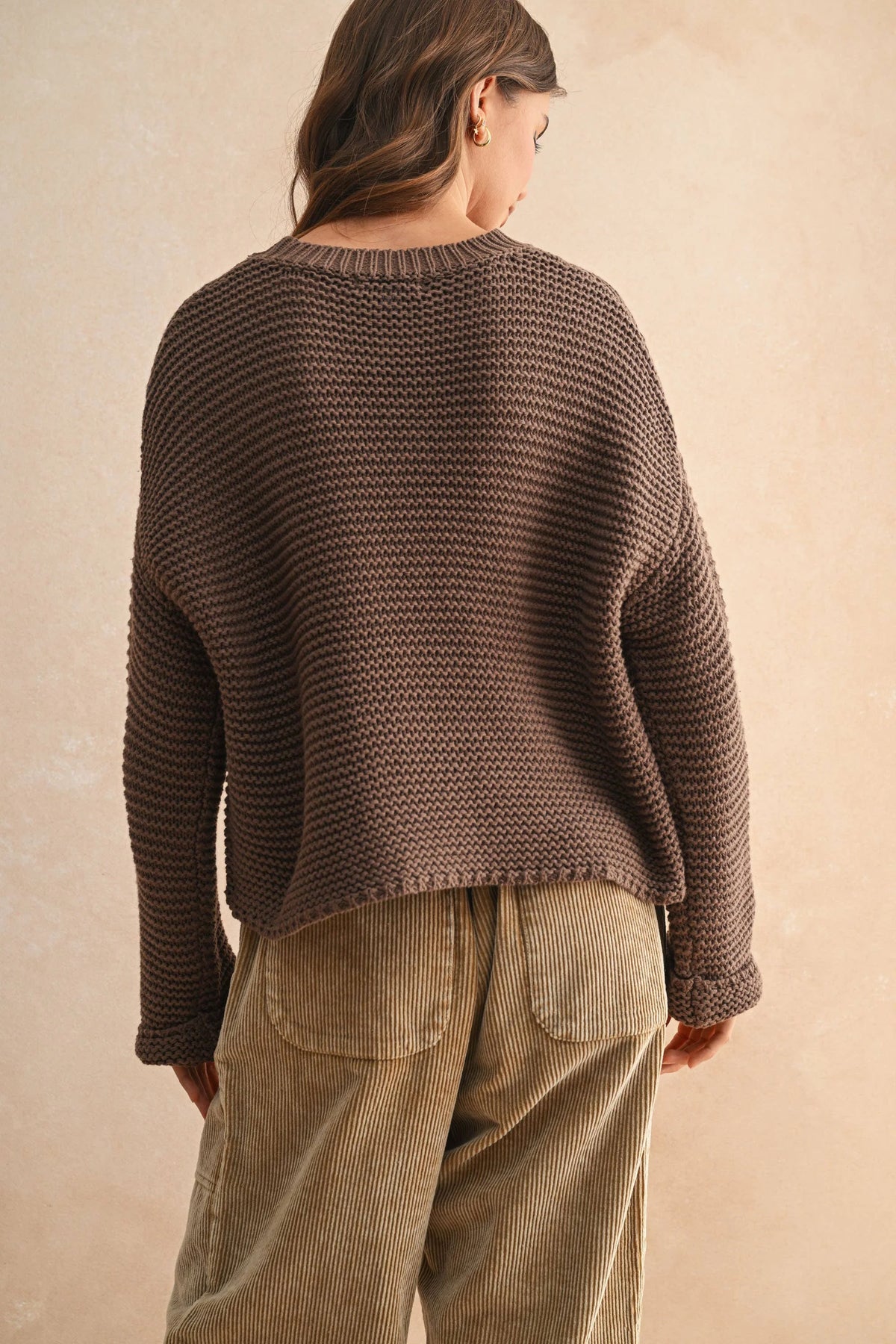 Brown round neck knitted sweater with textured fabric, corduroy pants