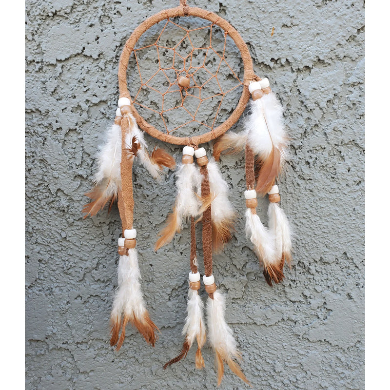 Brown and white mini dream catcher hanging on a wall for peaceful dreams