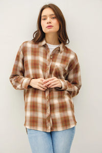 Brown and white plaid oversized flannel top worn over a white shirt for a classic look