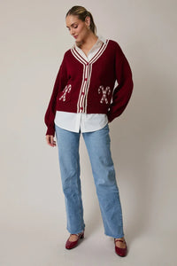 Burgundy candy cane graphic cardigan with white trim and buttons