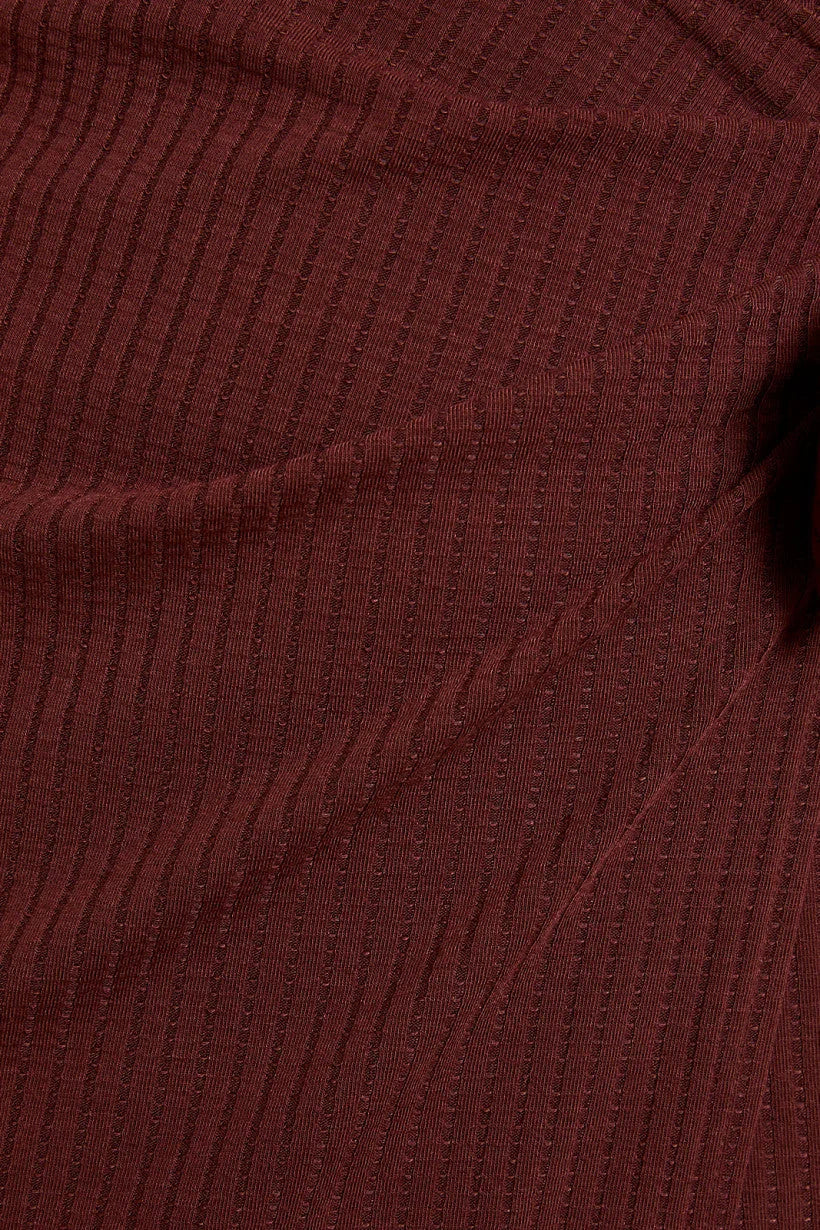 Burgundy corduroy fabric showcasing ribbed texture for Shop Daisy women’s boho chic clothing