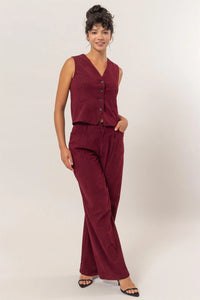 Burgundy sleeveless jumpsuit with button details, part of Shop Daisy’s women’s boho chic clothing