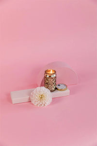 Sweet Grace Passion Fruit & Sparkling Tea Candle with a flower on a pink background