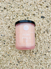 Candle on gravel ground showcasing Peony Petals Mini Candle design and elegance