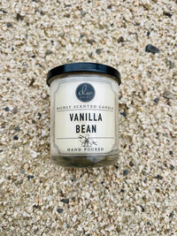 Candle labeled vanilla on the ground, showcasing the Vanilla Bean Mini Candle product