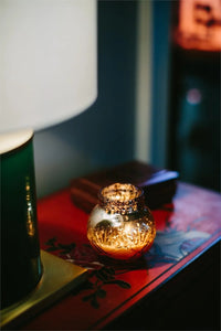 Soy-blend Sweet Grace Candle on a table with a book and lamp, best-selling fragrance candle