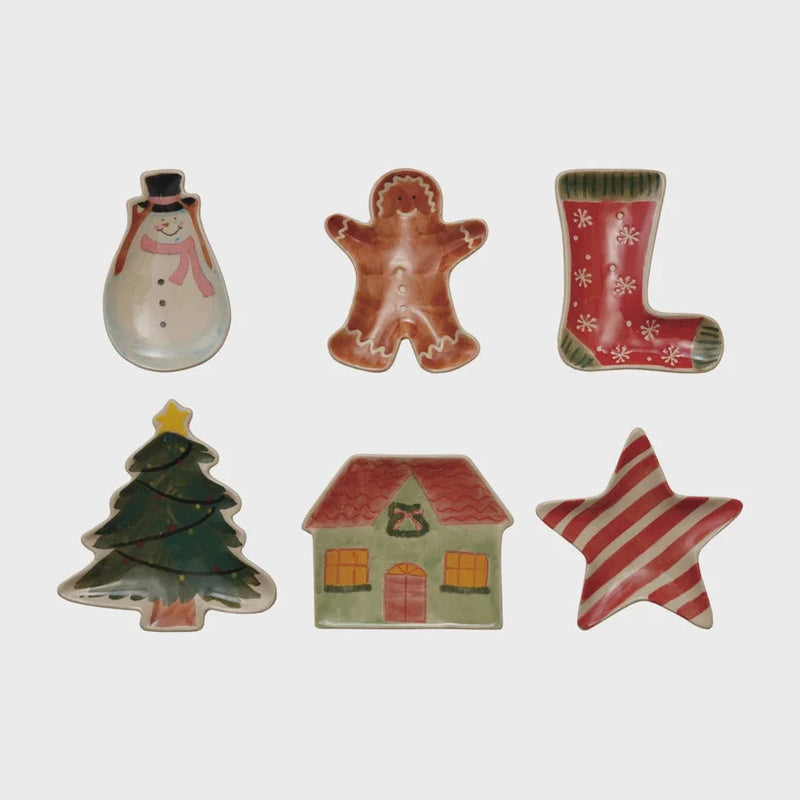 Ceramic gingerbread man ornament with red and brown glaze and snowflake accents on stoneware holiday shaped dish