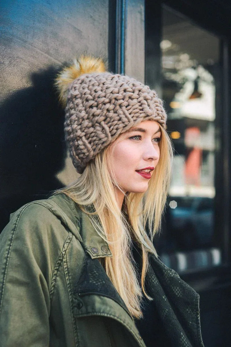 Chunky pom beanie with fur pom-pom styled with an olive green jacket