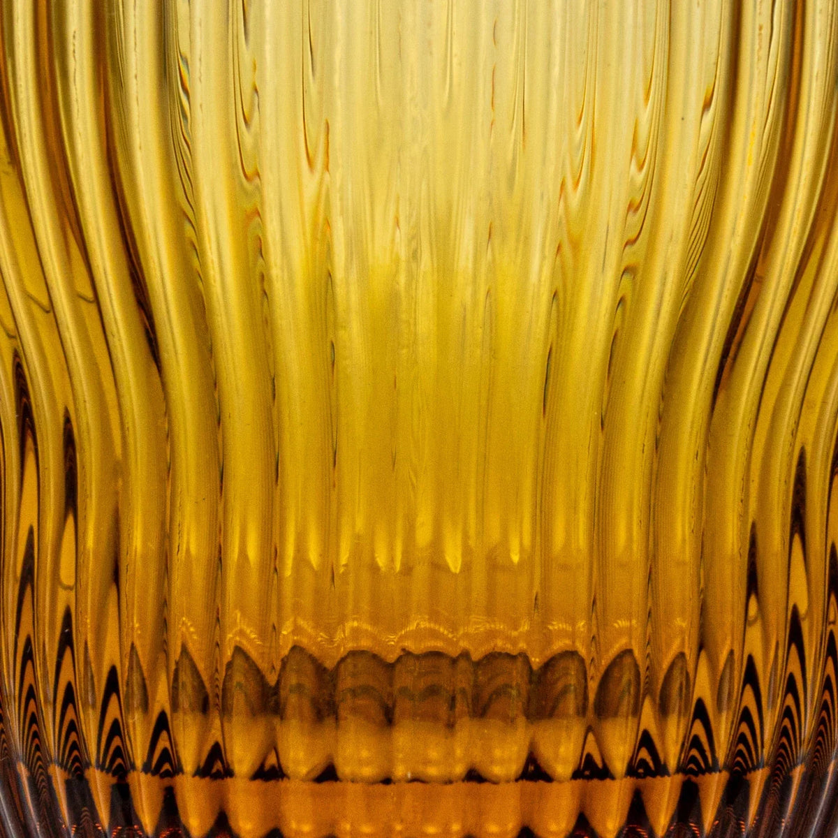 Close-up of a fluted drinking glass filled with yellow liquid for refreshing beverages