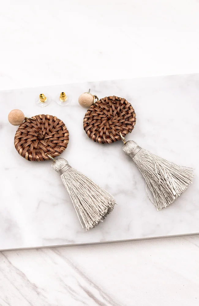 Close-up of Rattan Wicker Fringe Earrings with tassels on a marble surface