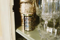 Close up of Sweet Grace Passion Fruit & Sparkling Tea Candle with decorative glasses