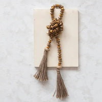 Close up of a Mango Wood Bead Garland with Jute Tassels for stylish decor