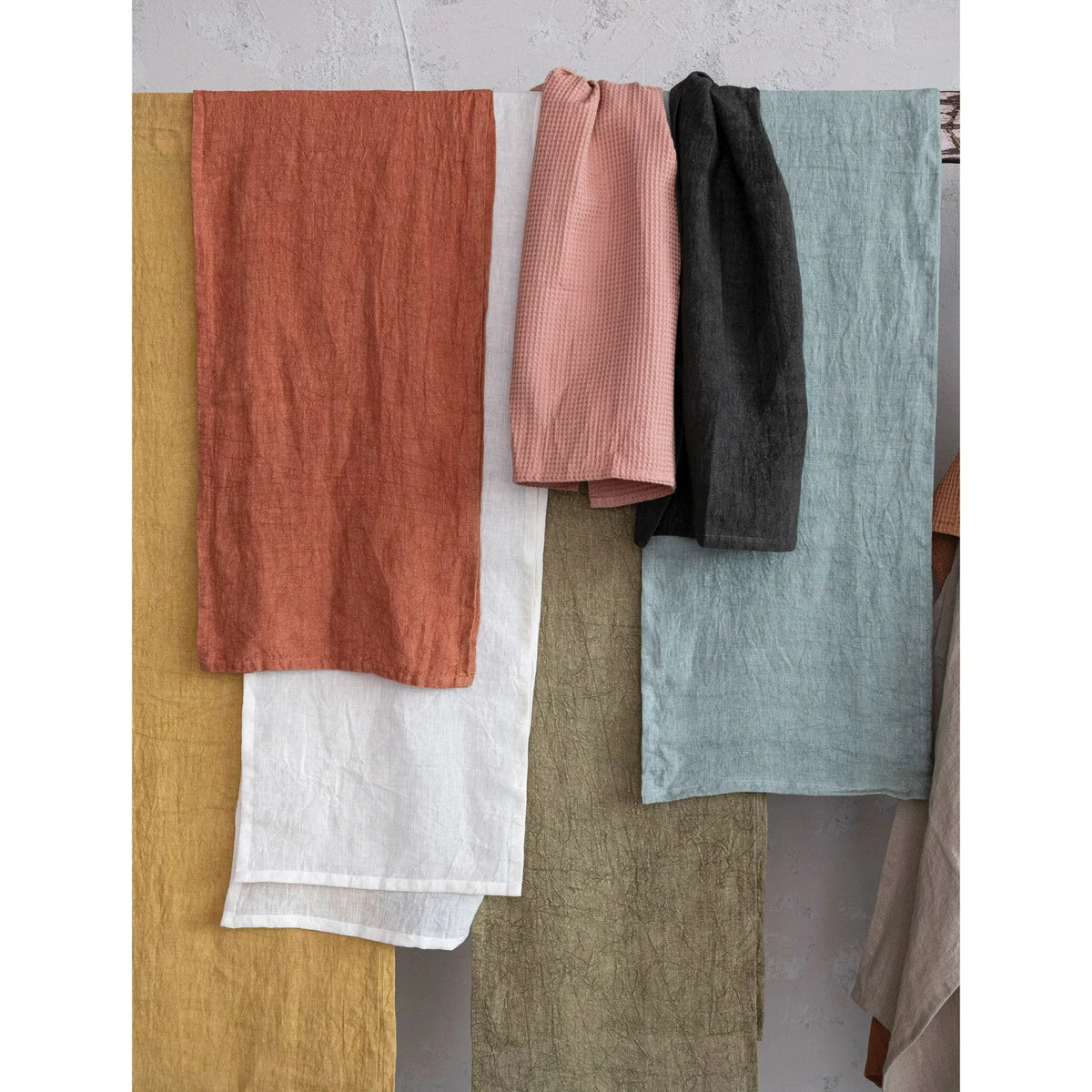 Collection of earthy fabric swatches for oversized stonewashed linen tea towel