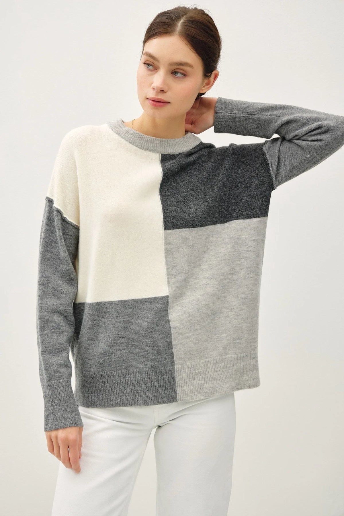 Color blocked crew neck sweater featuring grey, white, and charcoal sections