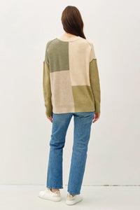 Color blocked crew neck sweater in olive green and beige paired with blue jeans