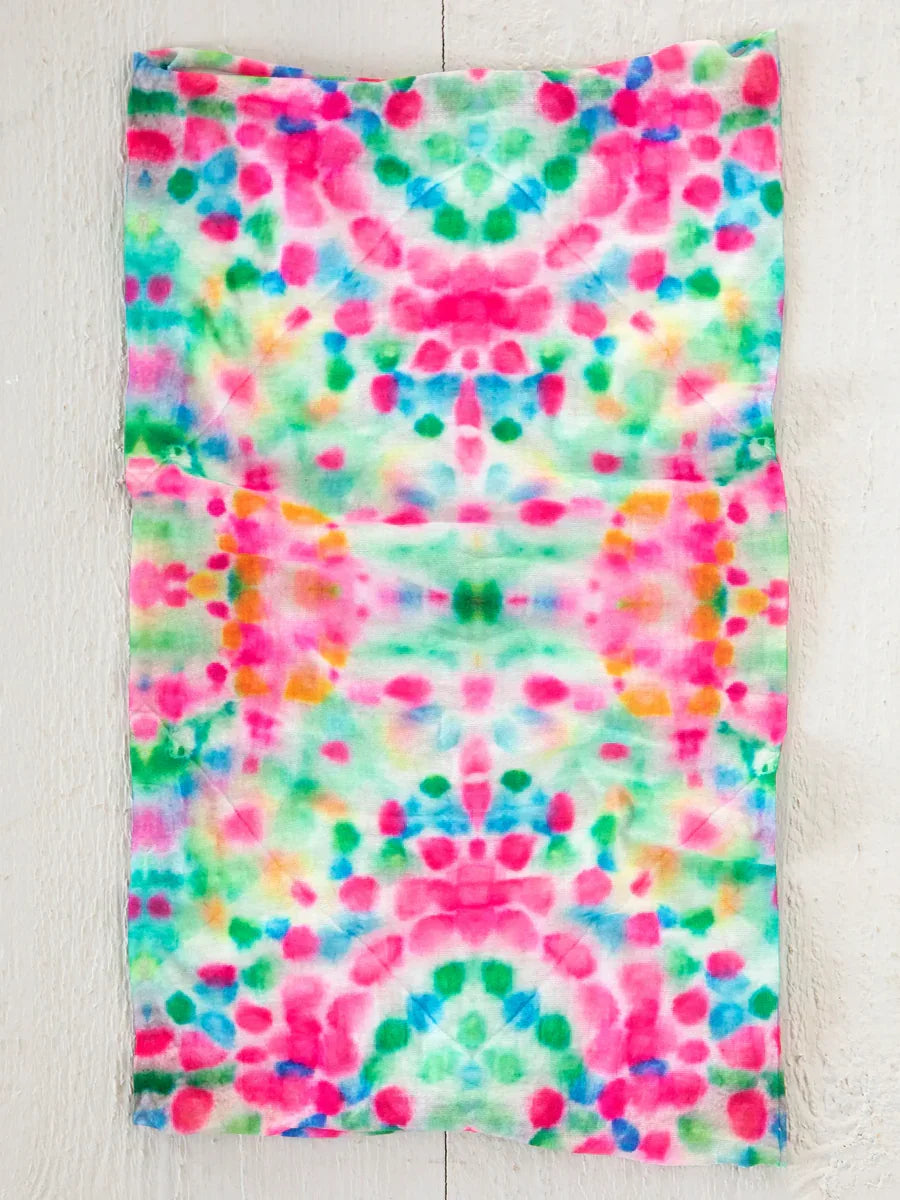 Colorful tie-dye fabric towel with pink and green splotches for boho free spirit style