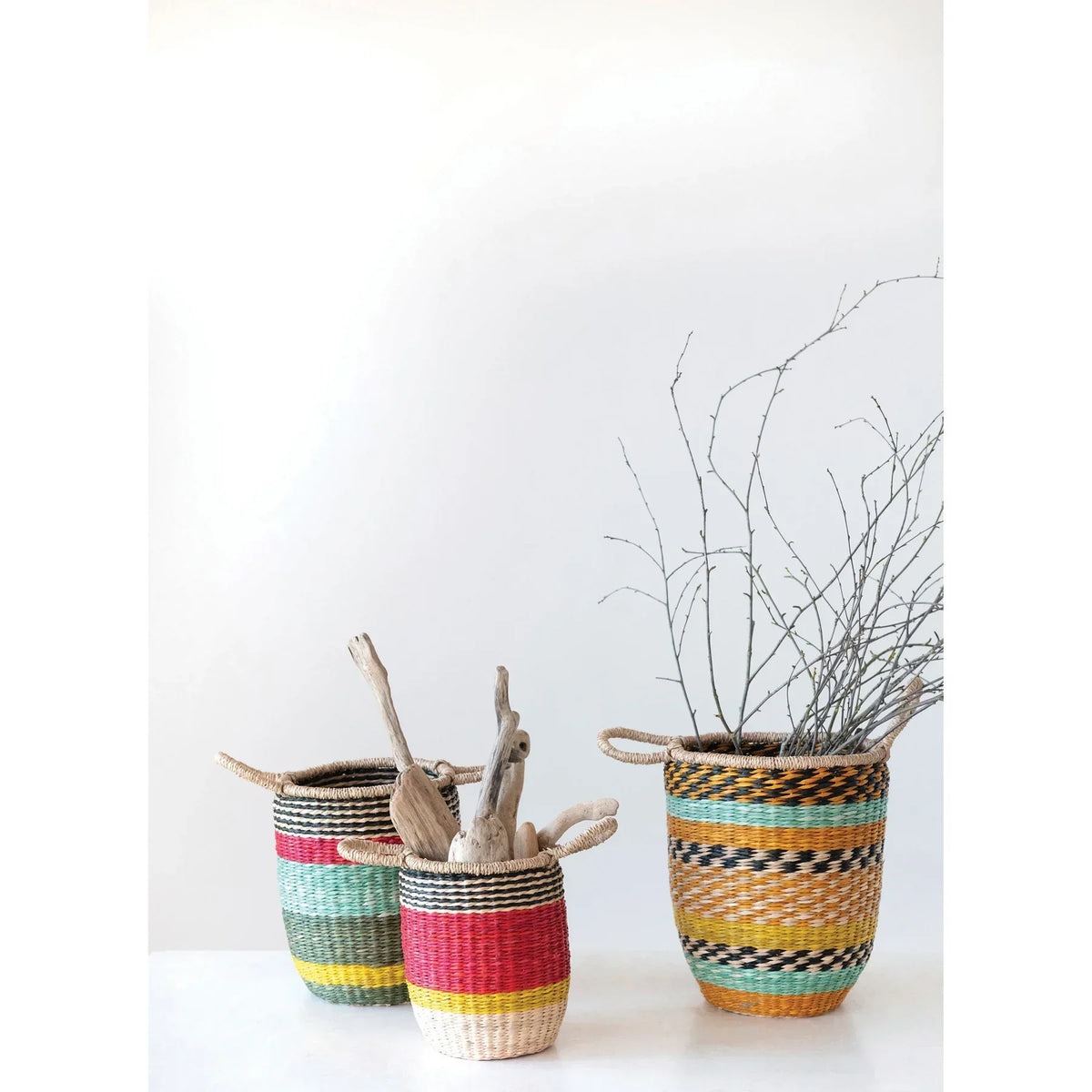 Colorful seagrass baskets with decorative patterns, perfect for boho chic decor from Shop Daisy