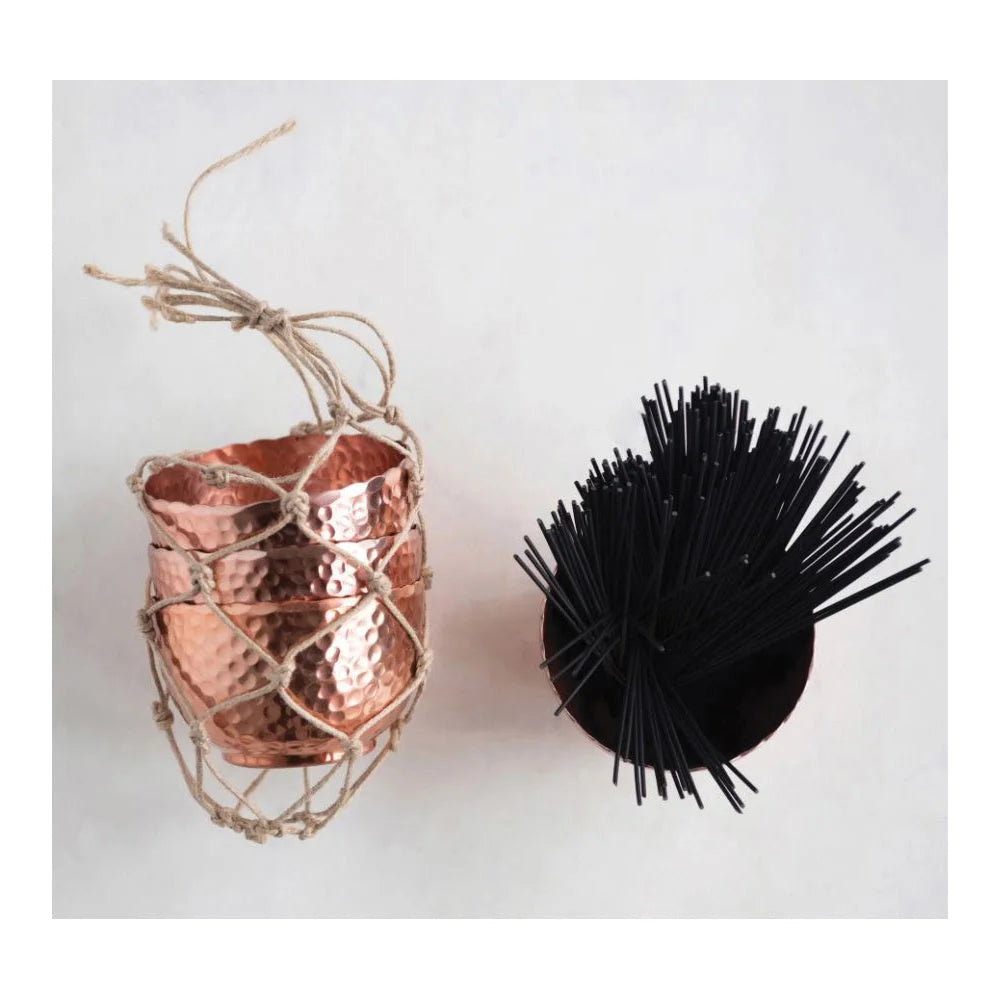 Copper-colored pineapple container next to a black spiky ball in hammered metal style