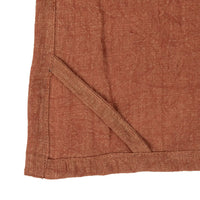 Corner detail of an oversized stonewashed linen tea towel with pocket and stitching