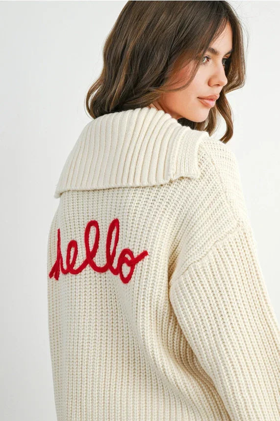 Knit collared V-neck long sleeve cream cable knit cardigan with red hello detail on back