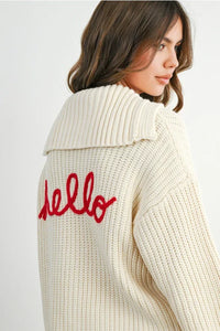 Knit collared V-neck long sleeve cream cable knit cardigan with red hello detail on back