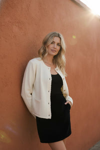 Long sleeve button down cardigan in cream with black dress underneath