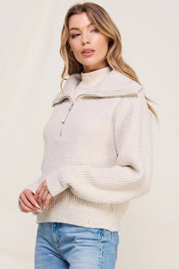 Cream-colored soft plush half zip pullover sweater with high collar and zipper