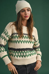 Cream-colored Aztec pattern sweater with green geometric design and matching beanie