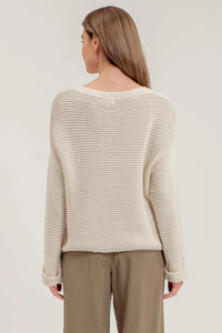 Cream-colored chunky knit pullover sweater worn by person from behind