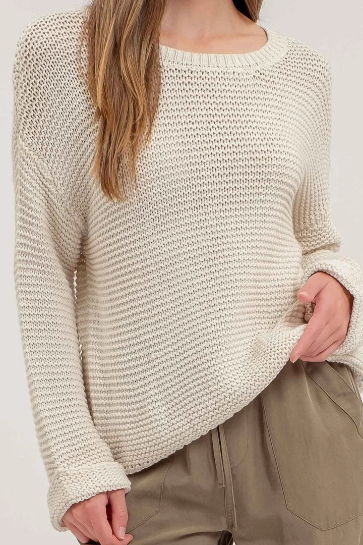 Cream-colored chunky knit pullover sweater with a loose, boho-style fit