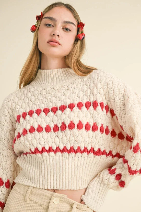 Cream-colored knit sweater with red heart patterns, part of the Color Popped Sweater collection